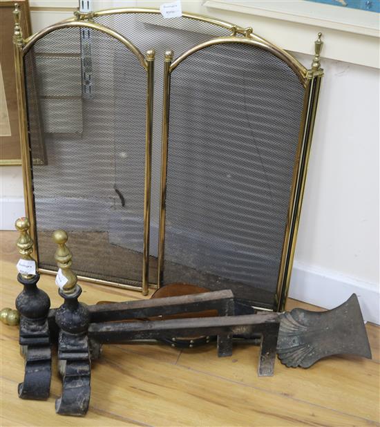 A pair of brass and cast iron fire dogs, a set of three fire brasses, a pair of bellows and a brass and gilt metal three fold guard